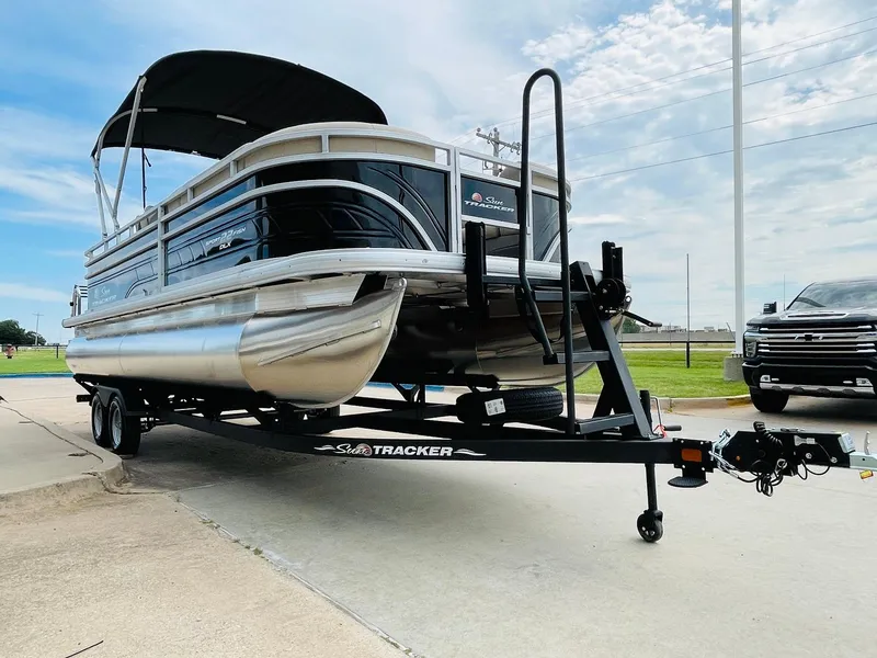 Slide: The Image of 2025 Sun Tracker SportFish 22 DLX pontoon boat on trailer, parked outdoors. - 3