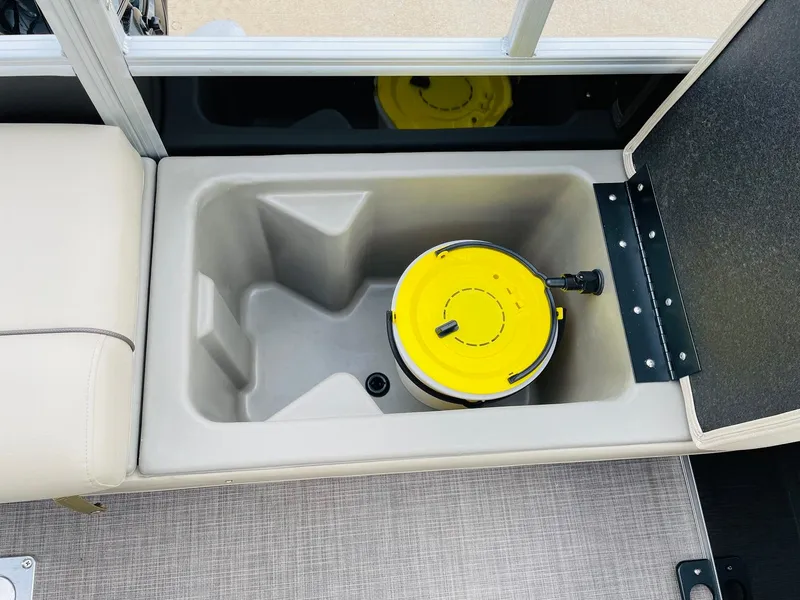 Slide: The Image of 2025 Sun Tracker SportFish 22 DLX storage compartment with yellow lid container. - 37