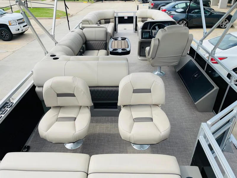 Slide: The Image of 2025 Sun Tracker SportFish 22 DLX pontoon boat interior with beige seating and modern design. - 7