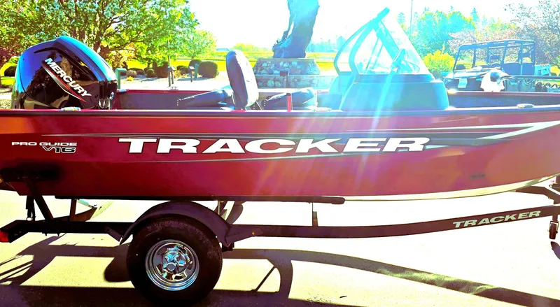 Slide: The Image of 2025 Tracker Pro Guide V-16 WT boat on trailer, outdoors in sunlight. - 5
