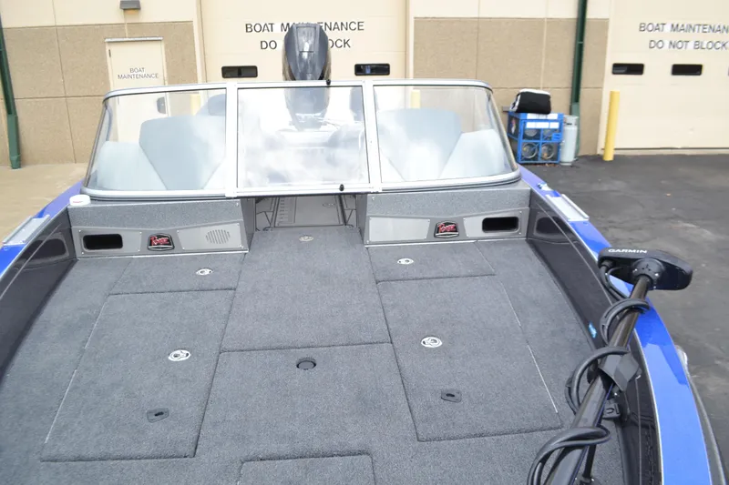 Slide: The Image of 2025 Ranger 621FS Pro boat interior with spacious deck and windshield, parked near maintenance area. - 5