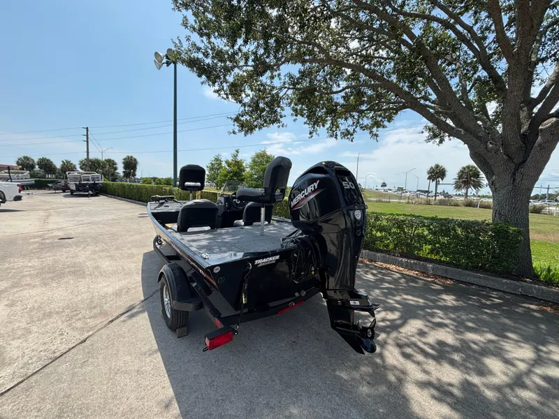 Slide: The Image of 2025 Tracker Bass Tracker Classic XL boat with Mercury engine, parked outdoors. - 2