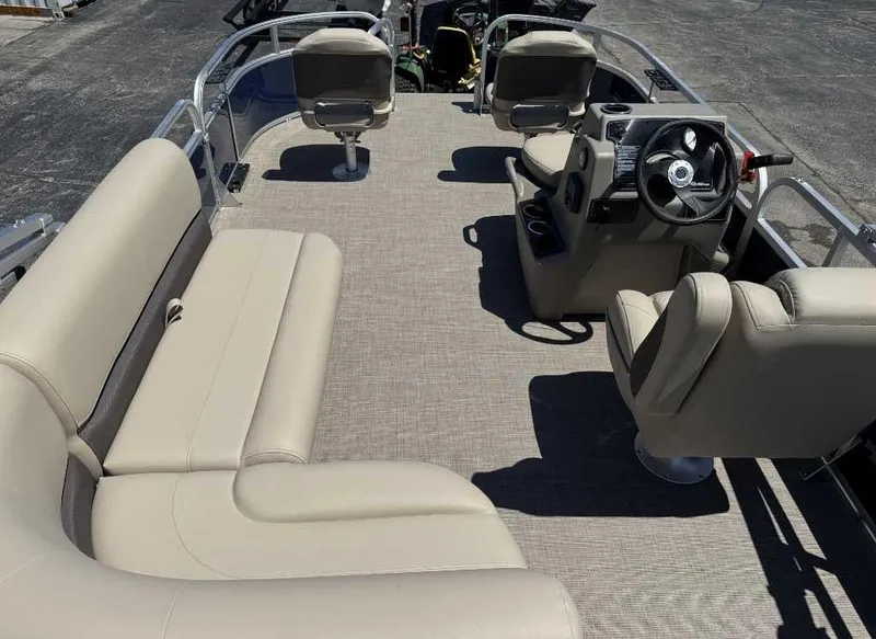 Slide: The Image of 2025 Sun Tracker Bass Buggy 16 XL Select pontoon boat interior with beige seating and steering console. - 6