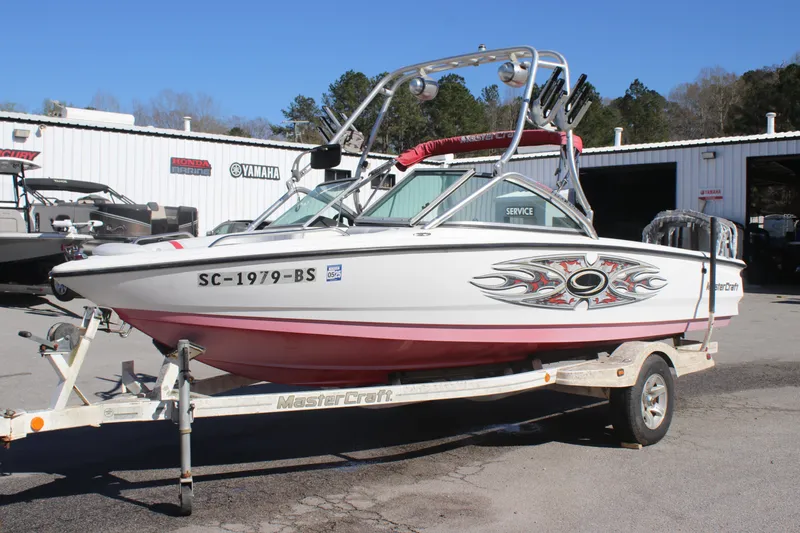 Slide: The Image of 2004 MasterCraft X-9 boat on trailer, parked outside a service center. - 0