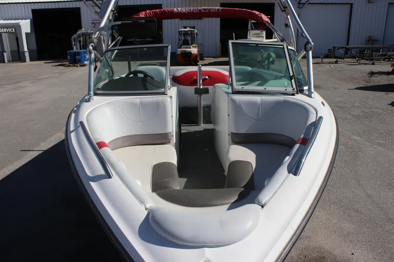 Slide: The Image of 2004 MasterCraft X-9 boat with open bow seating and windshield, parked outdoors. - 2