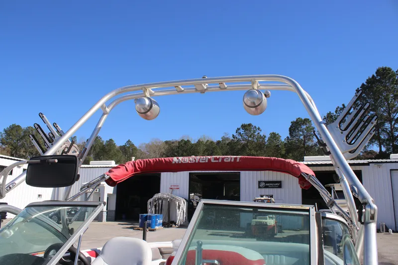 Slide: The Image of 2004 MasterCraft X-9 boat with wakeboard tower and speakers, parked outdoors. - 9