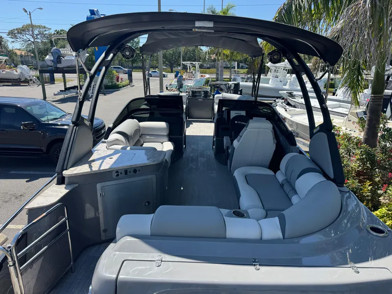 Slide: The Image of 2025 Avalon Excalibur 27' boat with luxurious seating and sleek design in a marina setting. - 14