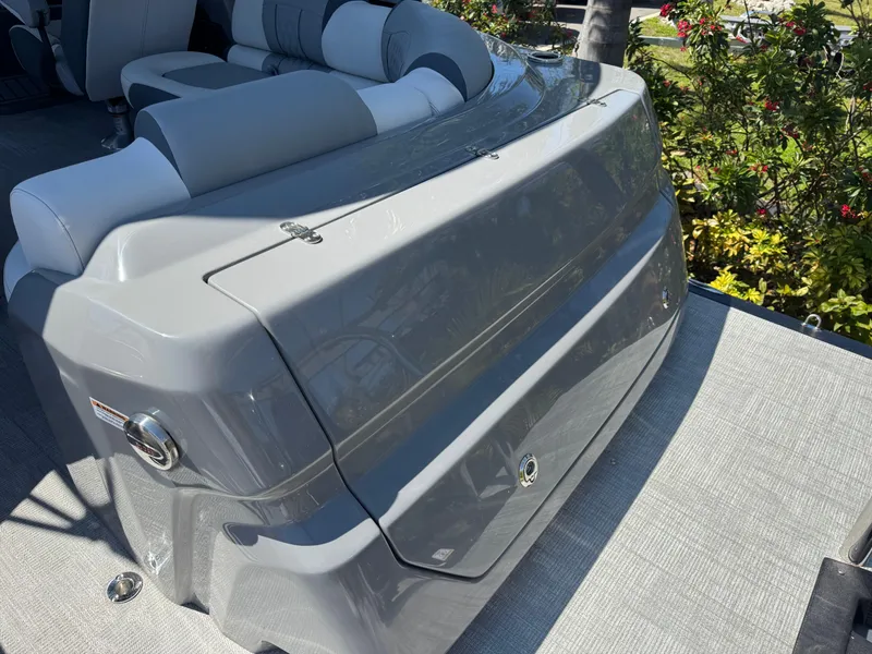 Slide: The Image of 2025 Avalon Excalibur 27' boat with sleek gray seating and lush greenery background. - 15