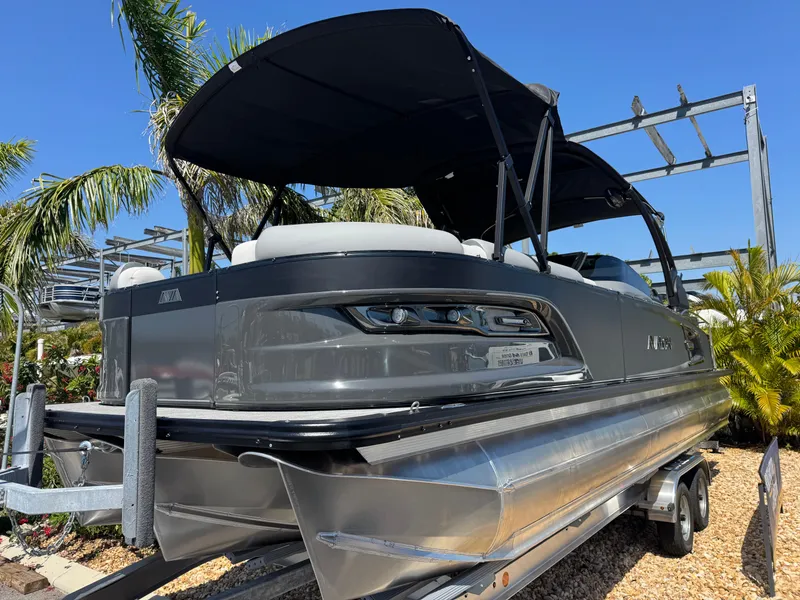 Slide: The Image of 2025 Avalon Excalibur 27' pontoon boat with sleek design and canopy, displayed outdoors. - 3