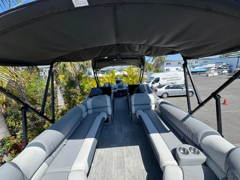 Slide: The Image of 2025 Avalon Excalibur 27' pontoon boat with spacious seating and canopy in a marina setting. - 32