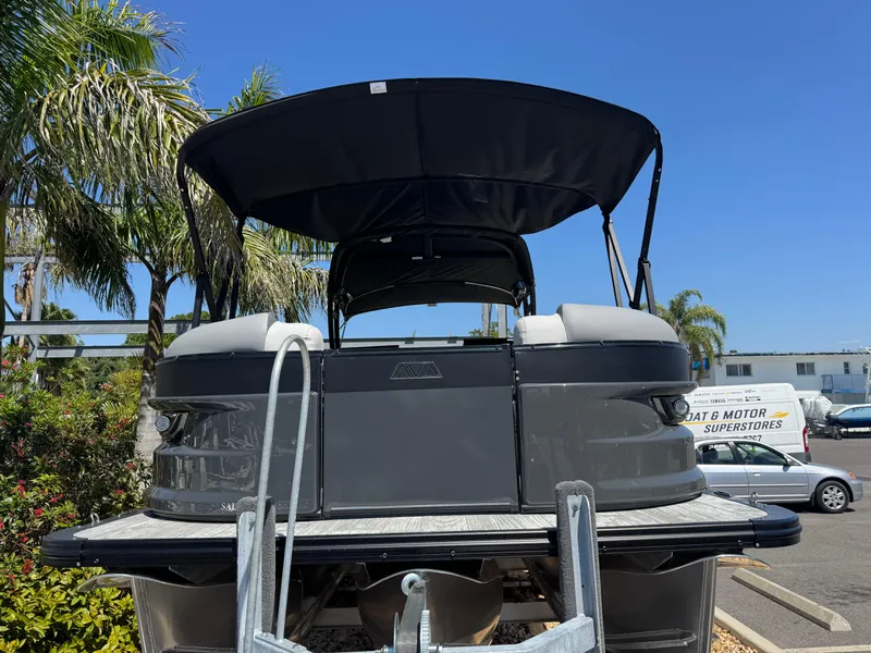 Slide: The Image of 2025 Avalon Excalibur 27' pontoon boat with canopy, parked outdoors under clear blue sky. - 4