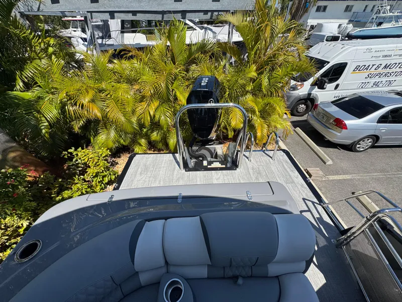 Slide: The Image of 2025 Avalon Excalibur 27' boat with seating, parked near palm trees and vehicles. - 41