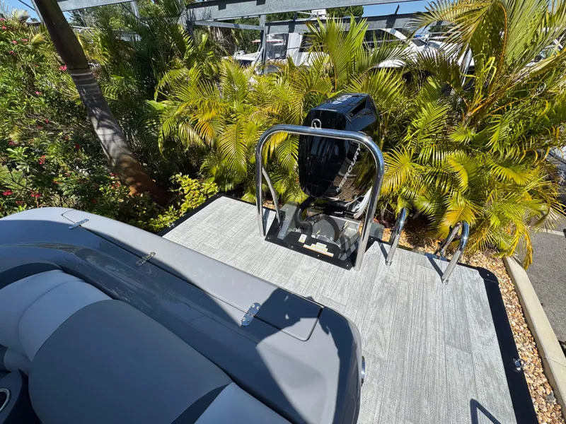 Slide: The Image of 2025 Avalon Excalibur 27' boat with sleek seating and powerful outboard motor, surrounded by lush greenery. - 42