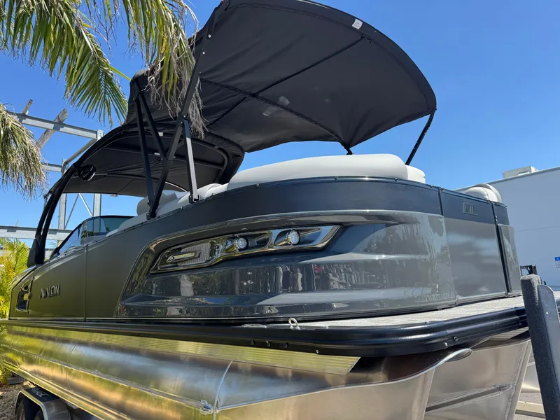 Slide: The Image of 2025 Avalon Excalibur 27' pontoon boat with canopy, sleek design under clear blue sky. - 5