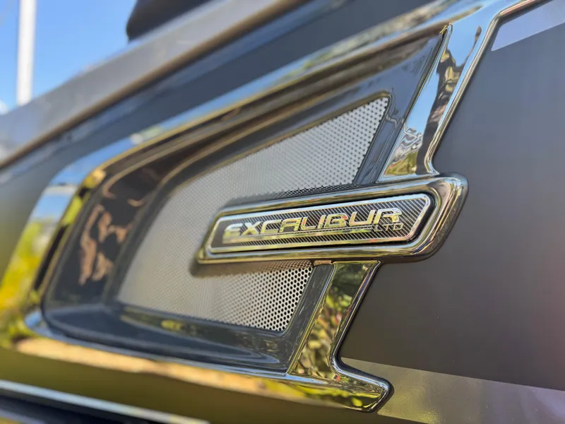 Slide: The Image of 2025 Avalon Excalibur 27' emblem close-up with sleek metallic design. - 8