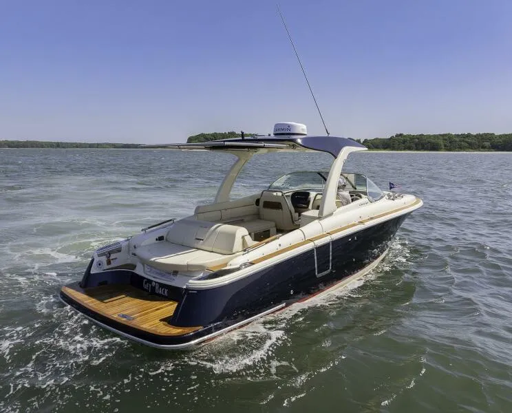 Slide: The Image of 2022 Chris-Craft Launch 31 GT boat cruising on a lake under clear skies. - 1