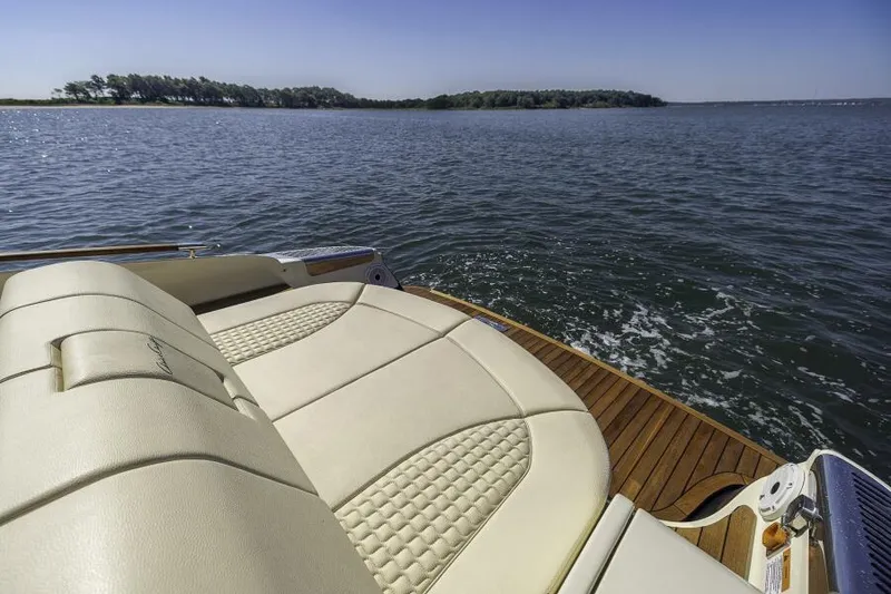 Slide: The Image of 2022 Chris-Craft Launch 31 GT boat with luxurious seating on a serene lake. - 10