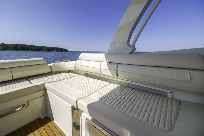 Slide: The Image of 2022 Chris-Craft Launch 31 GT interior with luxurious seating, overlooking serene water and clear sky. - 7