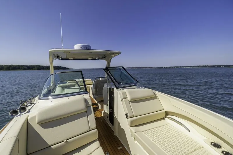 Slide: The Image of 2022 Chris-Craft Launch 31 GT boat on calm water, featuring luxurious seating and open deck. - 8