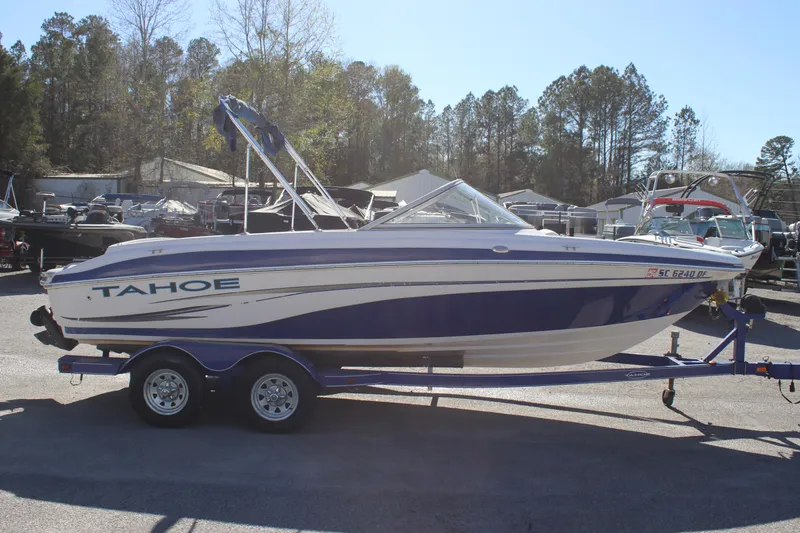Slide: The Image of 2007 Tahoe Q6 Sport boat on trailer, parked outdoors with trees in the background. - 2