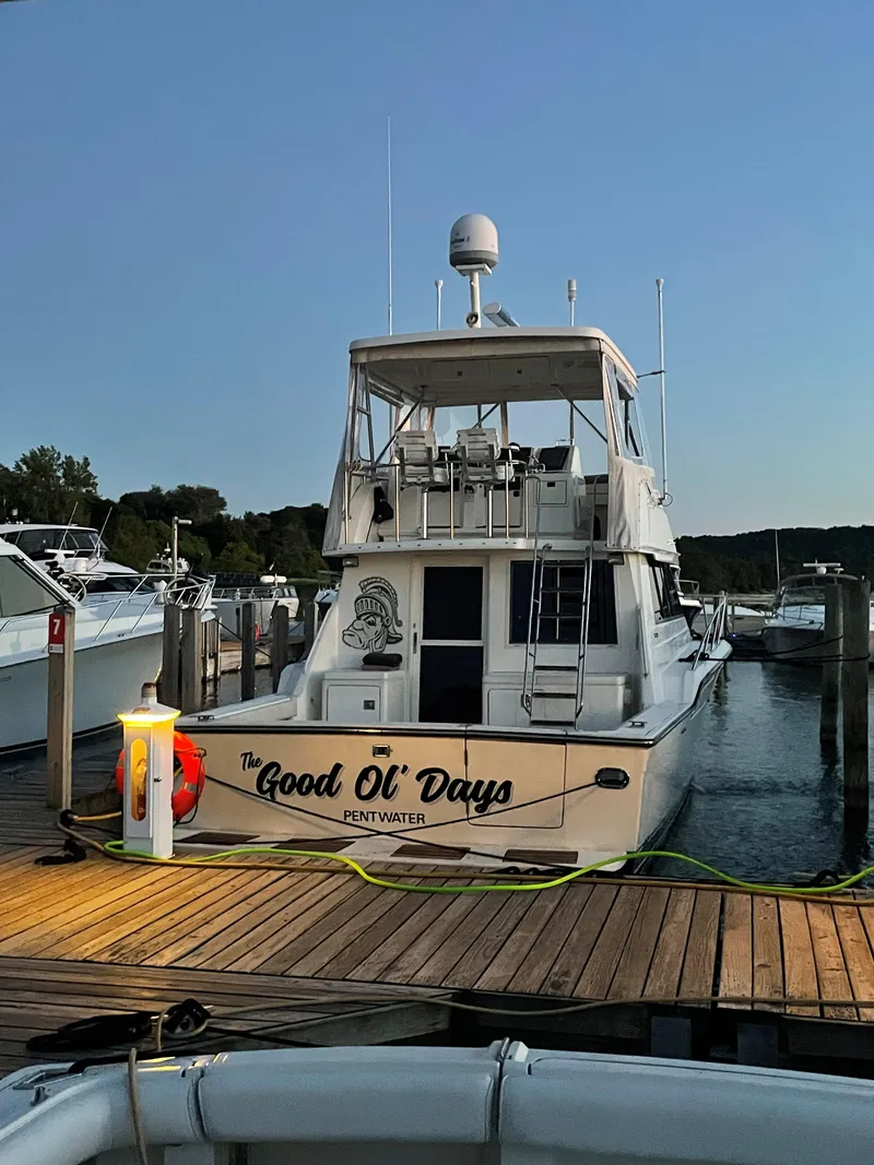Slide: The Image of 1990 Tiara Yachts 4300 Convertible docked, named "The Good Ol' Days," in a serene marina setting. - 10