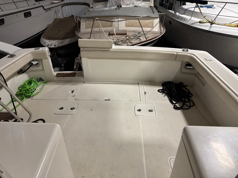 Slide: The Image of 1990 Tiara Yachts 4300 Convertible deck with ropes, docked alongside other boats. - 11