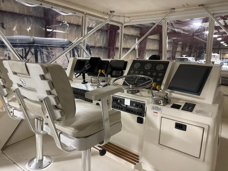 Slide: The Image of 1990 Tiara Yachts 4300 Convertible helm with navigation instruments and captain's chair. - 14