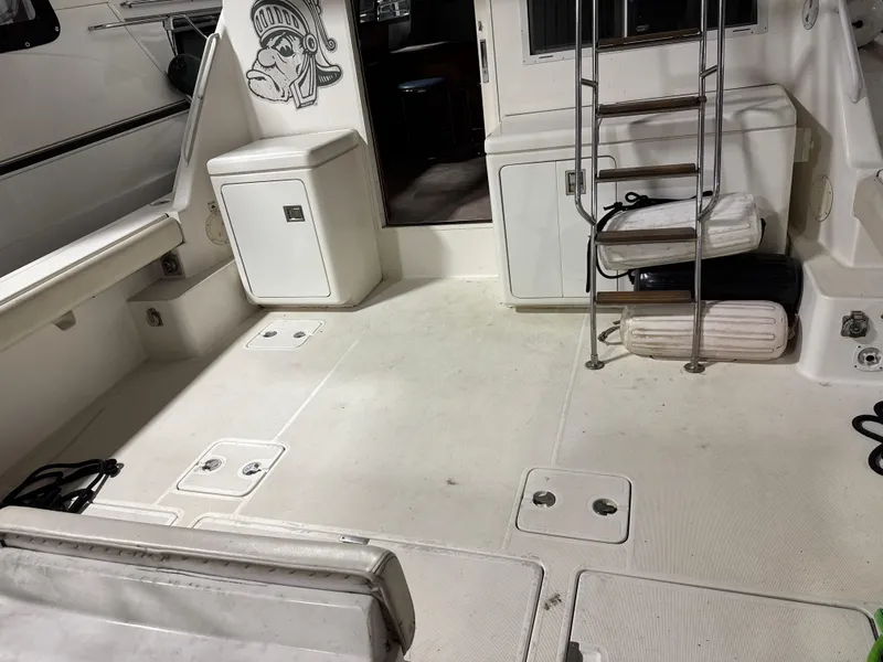 Slide: The Image of 1990 Tiara Yachts 4300 Convertible boat deck with ladder and storage compartments. - 29