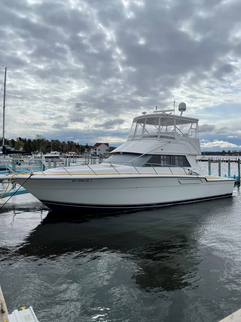 Slide: The Image of 1990 Tiara Yachts 4300 Convertible docked under cloudy skies. - 3
