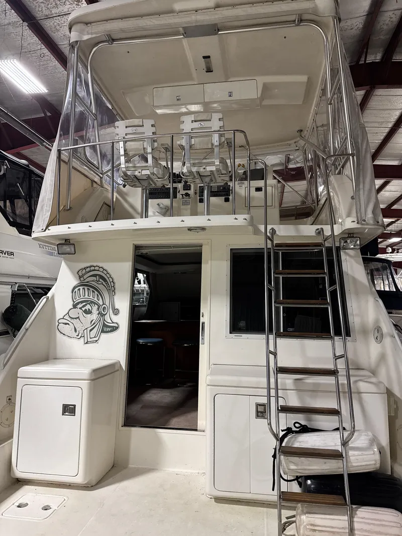 Slide: The Image of 1990 Tiara Yachts 4300 Convertible with upper deck and ladder in indoor storage. - 30