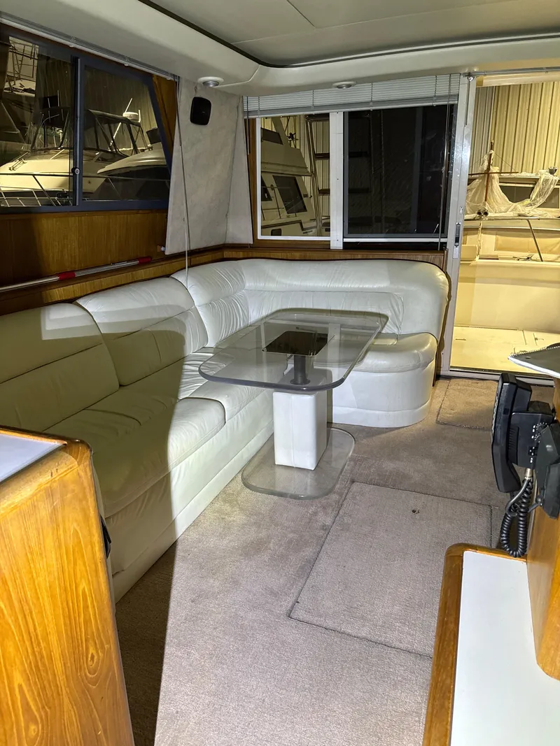 Slide: The Image of 1990 Tiara Yachts 4300 Convertible interior with white leather seating and glass table. - 35