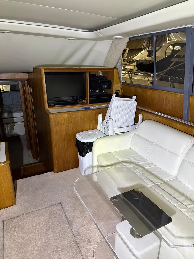 Slide: The Image of Interior of 1990 Tiara Yachts 4300 Convertible with white seating and wooden cabinetry. - 37