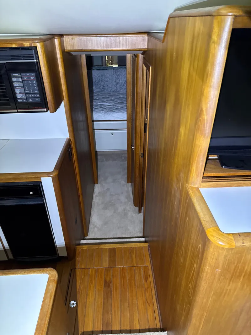 Slide: The Image of Interior view of 1990 Tiara Yachts 4300 Convertible, featuring wood cabinetry and compact layout. - 38