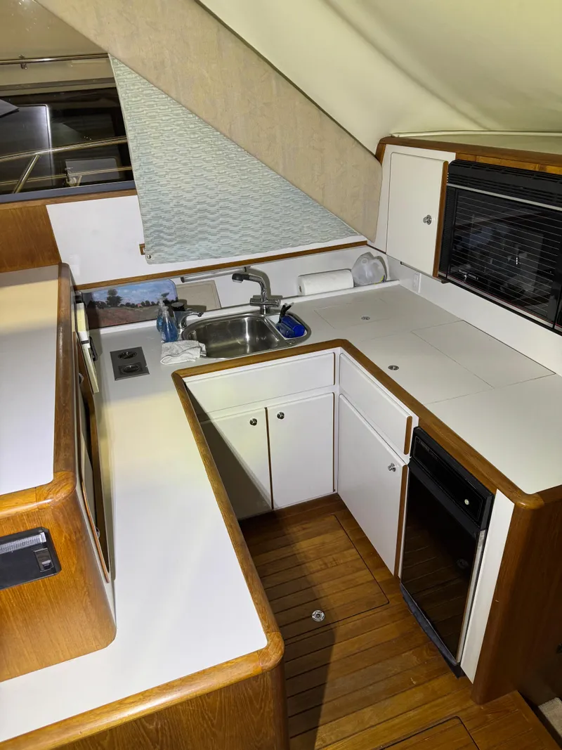 Slide: The Image of 1990 Tiara Yachts 4300 Convertible kitchen with wood accents and modern appliances. - 39