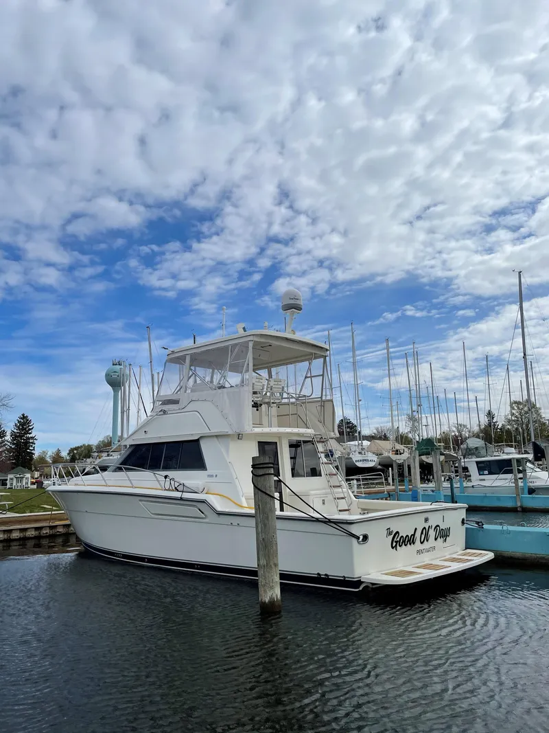 Slide: The Image of 1990 Tiara Yachts 4300 Convertible docked under a cloudy sky. - 4