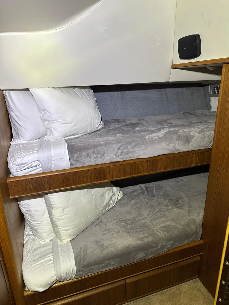 Slide: The Image of Bunk beds in 1990 Tiara Yachts 4300 Convertible cabin, featuring cozy bedding and wooden accents. - 42