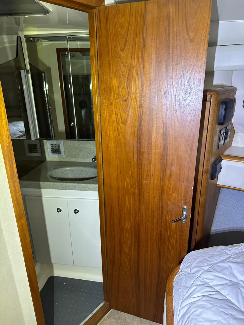 Slide: The Image of 1990 Tiara Yachts 4300 Convertible interior with wooden door, bathroom, and bedroom. - 45