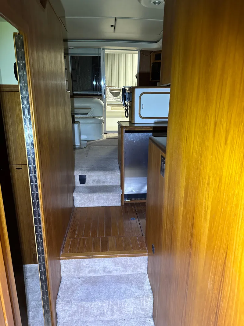 Slide: The Image of Interior view of 1990 Tiara Yachts 4300 Convertible, featuring wooden paneling and carpeted flooring. - 48