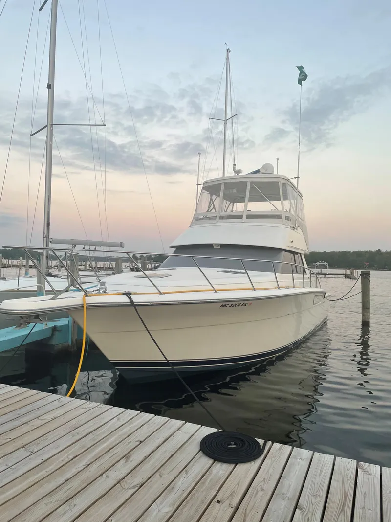 Slide: The Image of 1990 Tiara Yachts 4300 Convertible docked at sunset, showcasing sleek design and elegance. - 5
