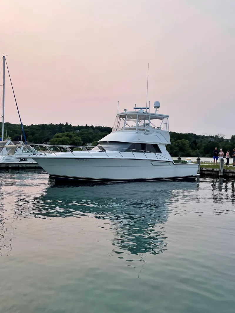 Slide: The Image of 1990 Tiara Yachts 4300 Convertible docked on calm water at sunset. - 9