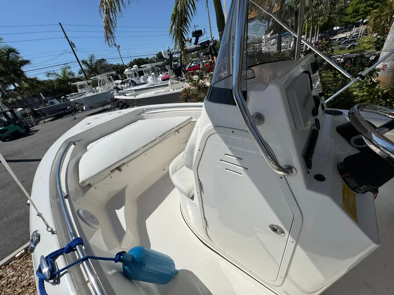 Slide: The Image of 2022 Key West 189 FS boat, white interior, console view, outdoor setting with palm trees. - 14