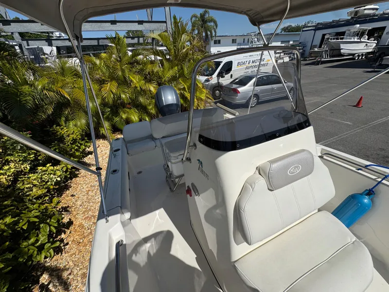 Slide: The Image of 2022 Key West 189 FS boat interior with seating and console, parked outdoors. - 18