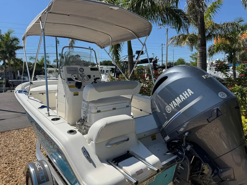 Slide: The Image of 2022 Key West 189 FS boat with Yamaha engine, parked outdoors under palm trees. - 9
