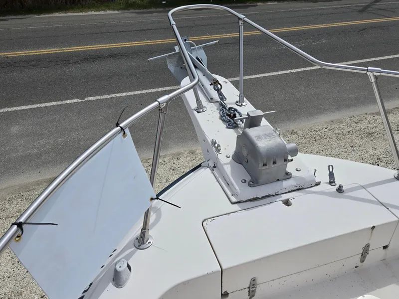 Slide: The Image of 1991 Grady-White 24 Offshore boat bow with anchor system, parked near a road. - 2