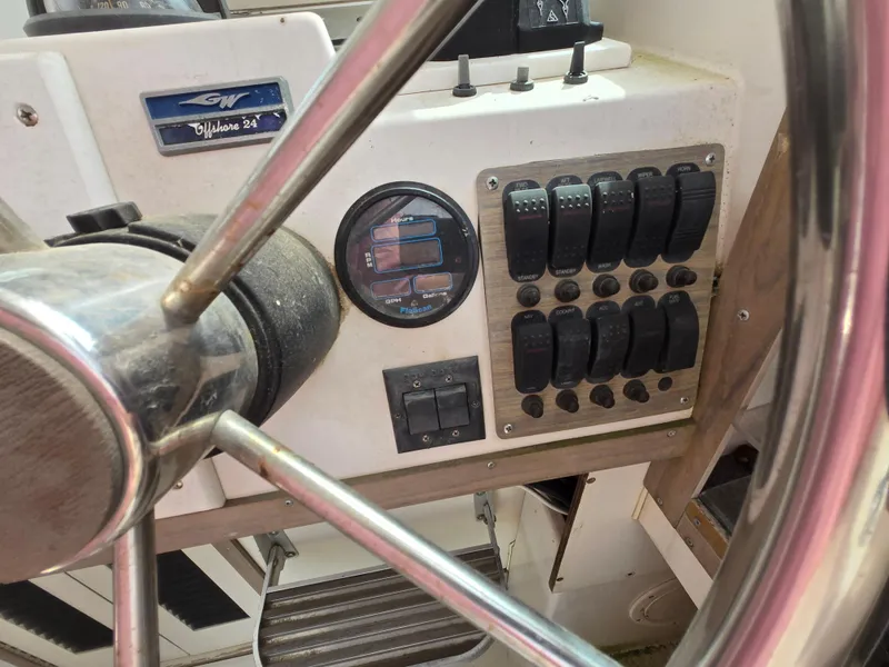 Slide: The Image of 1991 Grady-White 24 Offshore boat dashboard with steering wheel and control panel. - 9