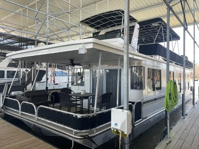 Slide: The Image of Houseboat docked in marina, Sunstar 16x58 model, 2016, with outdoor seating area. - 1