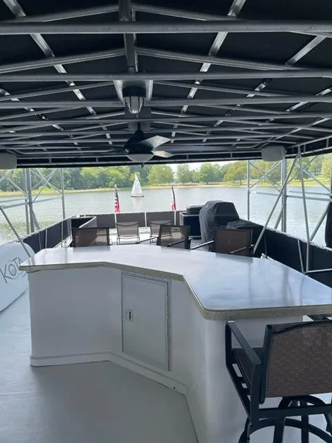 Slide: The Image of Spacious Sunstar 16x58 houseboat deck with seating, bar area, and scenic water view, 2016 model. - 23