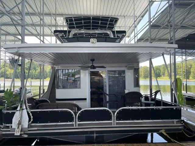 Slide: The Image of Houseboat docked under a canopy, Sunstar 16x58 model, 2016, with outdoor seating area. - 25