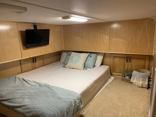 Slide: The Image of Cozy bedroom in 2016 Sunstar 16x58 houseboat with TV, wooden cabinets, and plush bedding. - 27
