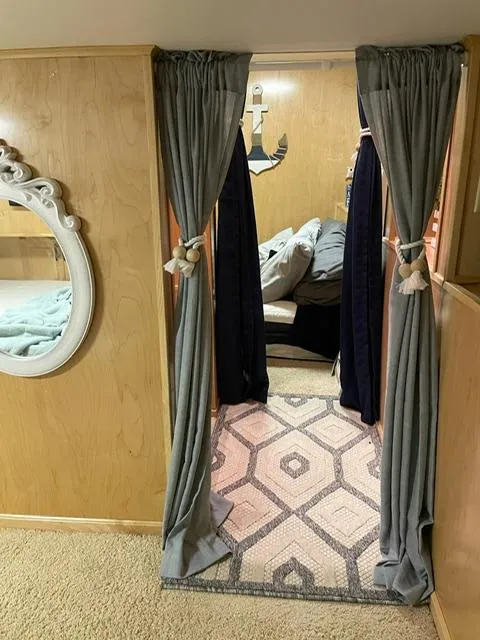 Slide: The Image of Cozy interior of a 2016 Sunstar 16x58 houseboat with curtains and nautical decor. - 28